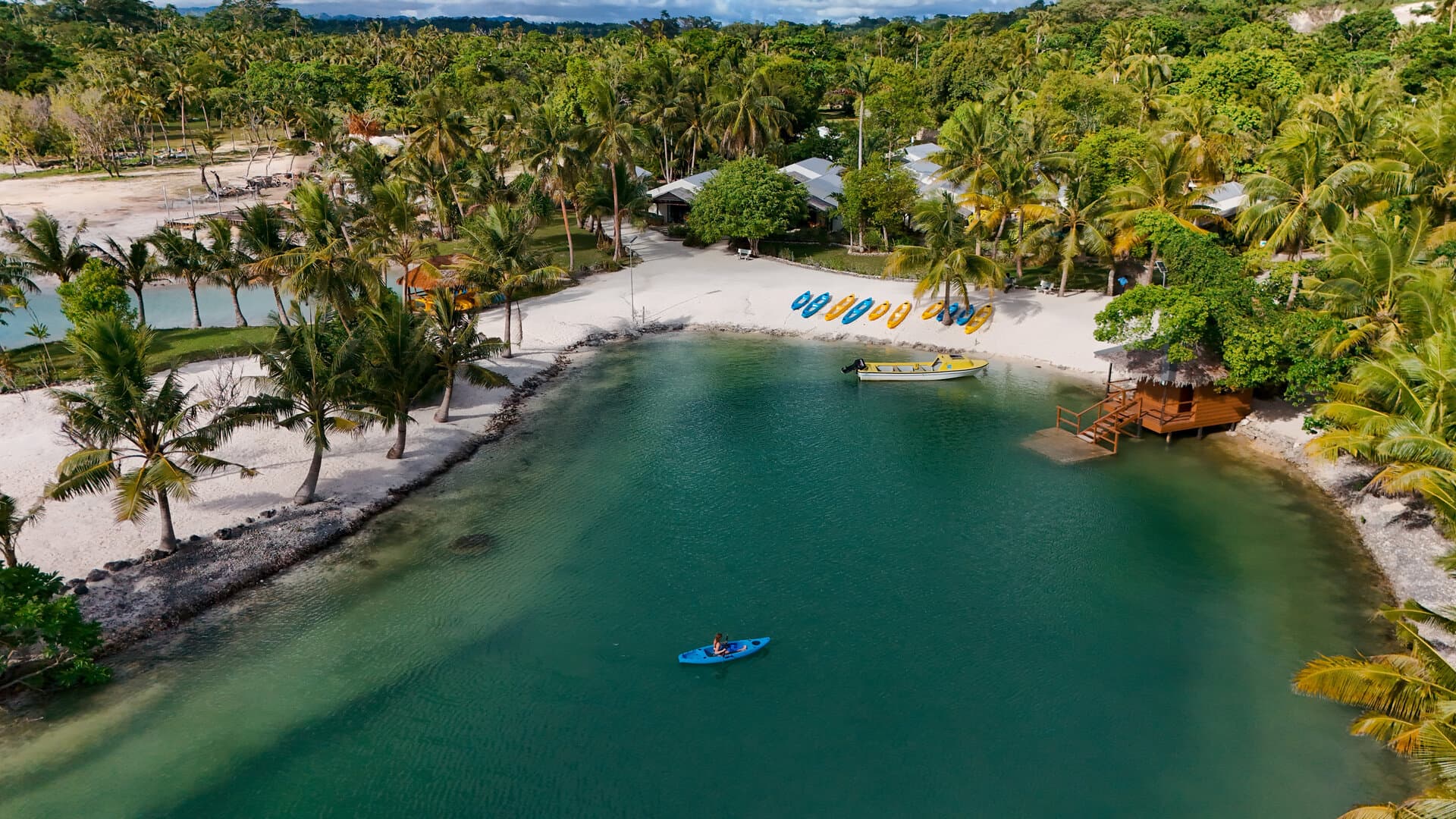 E'Nauwi Beach Resort panoramic view β lagoon with kayaks